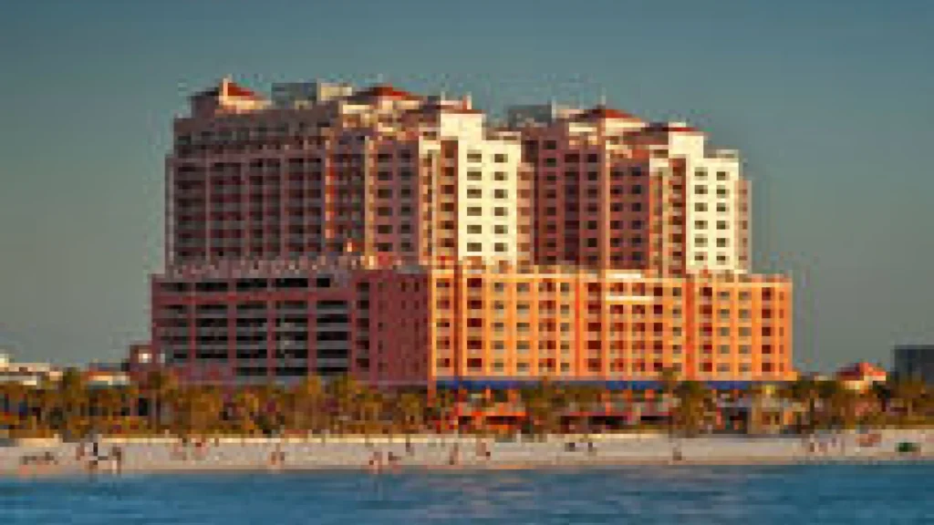 Exterior view of an old building with a beach and palm trees outside